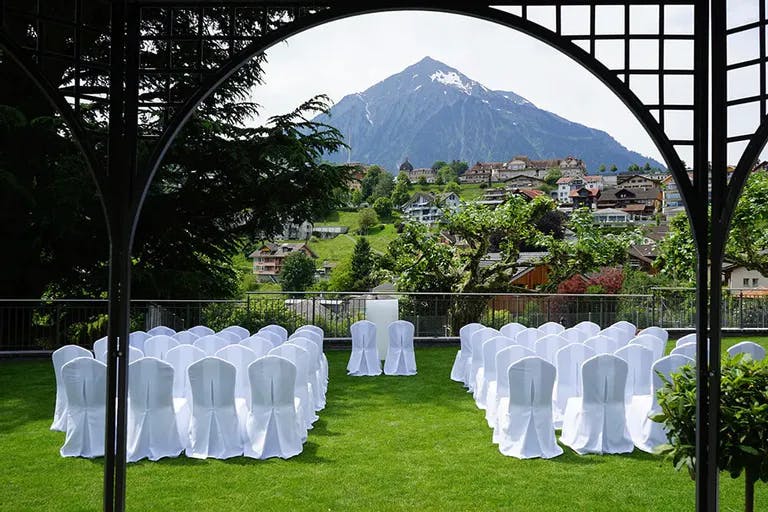 Hochzeitszeremonie im Garten eines Hotels in den Bergen.
