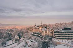 Dolder Grand mit verschneiter Landschaft und Aussicht auf Zürich