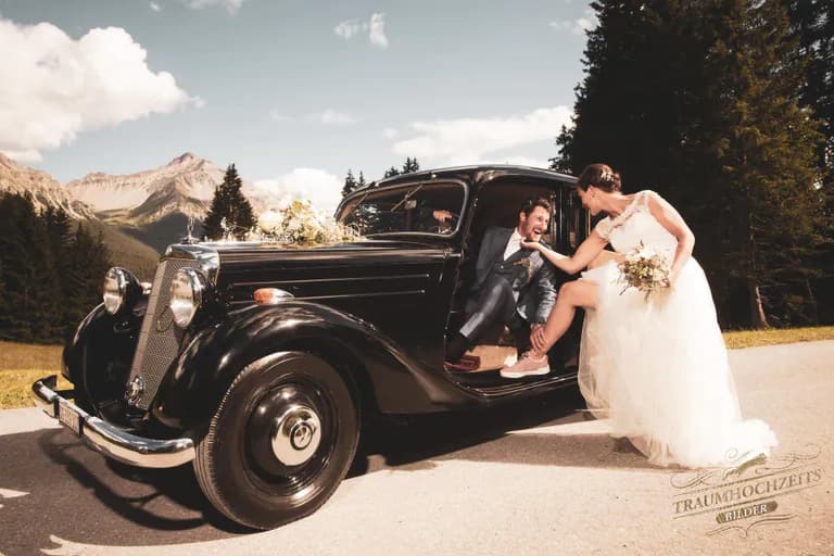 Brautpaar mit Oldtimer Auto vor Berglandschaft