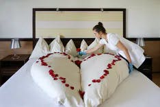 Hochzeitssuite mit hergerichtetem Bett und Herz aus Rosenblättern