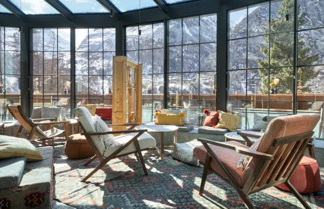 Cervo Mountain Resort Wintergarten mit Stühlen und Blick auf die Natur mit den Zermatter Bergen