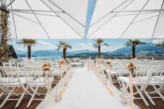 Hochzeitszeremonie im Art Deco Hotel Montana Luzern mit Stühlen und Palmen für Trauung und Blick auf den Vierwaldstättersee