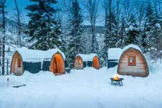Holzhäuser im Schnee mitten in der Winterlandschaft