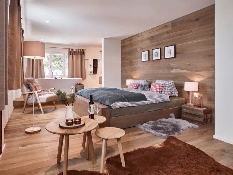 Zimmer in der Atzmaennig Lodge mit Bett und Holzboden