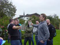 Gruppe Männer mit Humpen beim Bier-Fun-Wettkampf