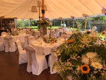 Tischen mit Stuhlhussen für Hochzeitsfest in der Location Maxililian