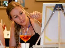 Teilnehmerin der ArtNight beim malen eines Bilds mit eine Drink