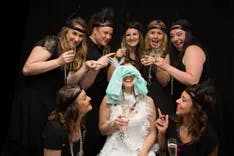 Gruppe von Frauen beim Polterabend Fotoshooting mit der Braut in der Mitte