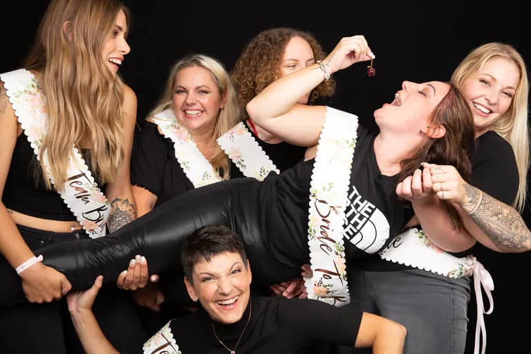 Braut wird von Freundinnen in die Luft gehoben für ein Foto Shooting