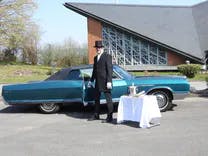 Buick mit Fahrer, der die Türe öffnet für das Hochzeitspaar