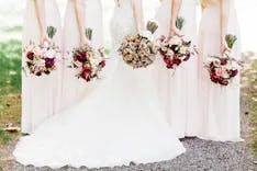 Braut mit Hochzeitsgästen alle in weiss gekleidet mit Blumensträussen