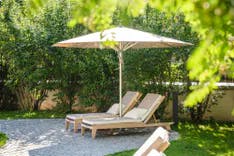 Zwei Liegestühle und ein Sonnenschirm im Parkhotel Margna