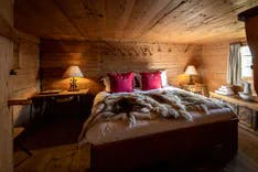 Bett in der Walig Hütte mit Holzdecke und Holzboden