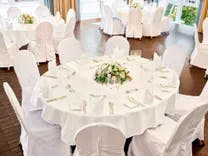Gedeckte runde Tische mit Stühle für ein Hochzeit im Saal des Grand Casino Baden