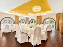 Gedeckte Tische und Stühle mit Stuhlhussen für ein Abendessen einer Hochzeit im Grand Casino Baden