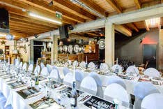Dekorierter Saal mit weissen Tischtüchern und Stühlen für ein Hochzeit in der Braustation in Sursee