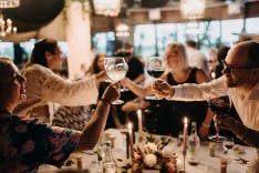 Hochzeitsgäste erheben das Weinglas und stossen gegenseitig an
