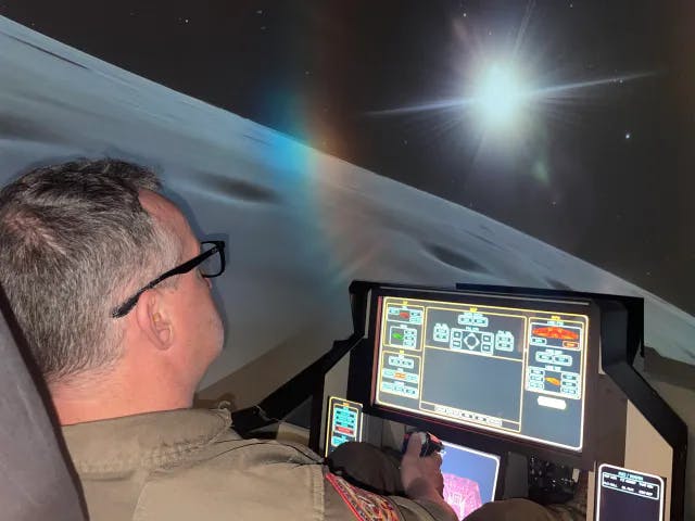 Herr fliegt im Space Simulator mit Blick auf einen Planeten