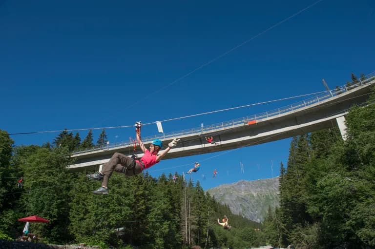 Brücke im Hintergrund und vorne eine Person, die sich am abseilen ist