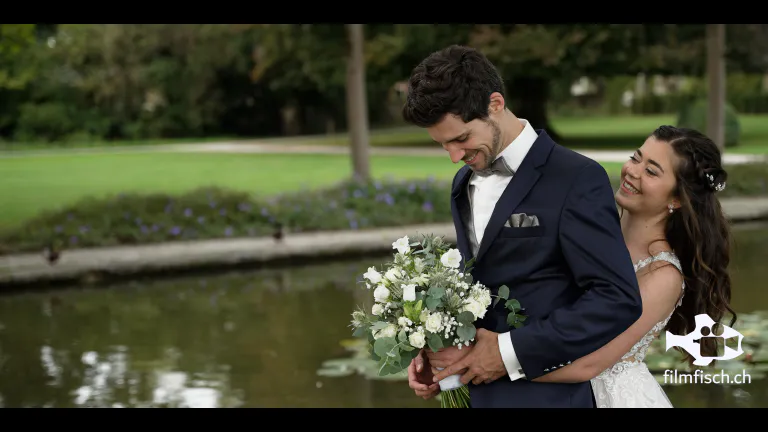 Die Braut hält den Bräutigam von hinten beim first Look