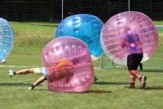 Drei Teilnehmer beim Bubble Soccer bei einem Polterabend