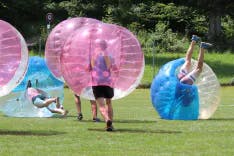 Mehrere Teilnehmer beim Bubble Soccer spielen bei einem Polterabend