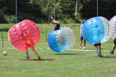 Mehrere Teilnehmer bei einem Polterabend beim Bubble Soccer Spielen