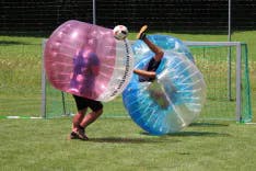 Harter Check beim Bubble Soccer Spielen bei einem Polterabend