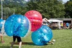 Mehrere Teilnehmer beim Bubble Soccer Spielen draussen