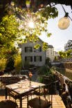 Schlosserei by Aaria Gebäude mit Sonne im Hintergrund vom Garten aus fotografiert