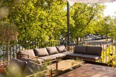 Blick auf die Lounge mit Bäumen im Garten der Schlosserei by Aaria