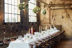 Weiss gedeckter Tisch und Blumendekoration sowie Kerzenlich für ein Hochzeitsessen in der Giesserei Oerlikon