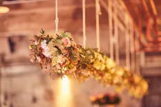 Blumen als Hochzeitsdekoration hängen an einer Schnur von der Decke