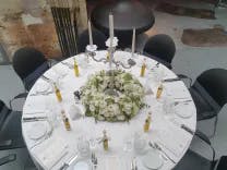Blick von oben auf einen runden Tisch schön dekoriert für eine Hochzeitsfeier inklusive Blumen