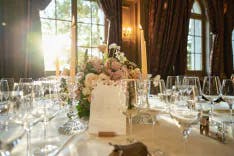 Gedeckter runder Tisch mit Kerzen und Blumen für ein Abendessen bei einem Hochzeit
