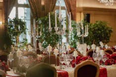 Kerzenständer und gedeckte Tische für ein Hochzeitsabendessen im Gstaad Palace