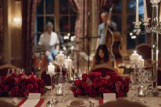 Mit Blumen dekorierter Tisch mit Musiker im Hintergrund für eine Hochzeitsfeier