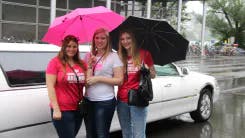 Drei Frauen stehen vor einer Limousine bei einem Junggesellinnenabschied