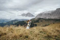 Brautpaar küsst sich in Mitten der Berglandschaft