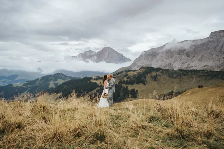 Brautpaar küsst sich in Mitten der Berglandschaft