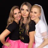 Braut posiert mit zwei Kolleginnen beim Fotoshooting eines Junggesellenabschieds