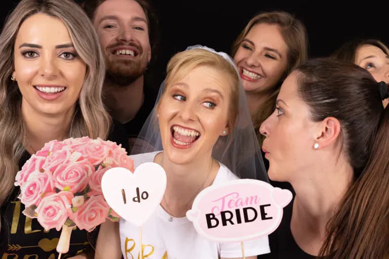 Gruppe von Frauen mit Schilder beim Fotoshooting eines Junggesellenabschieds